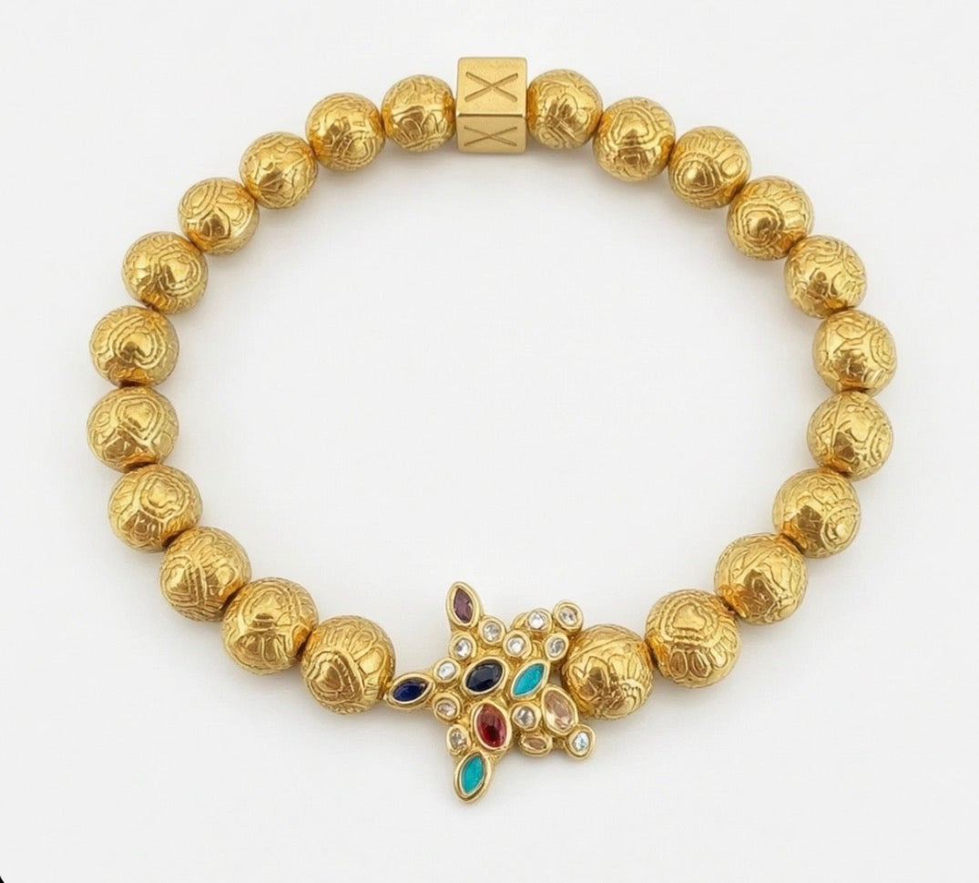 Limited Edition - Aurea Varium bracelet featuring intricately textured gold beads and a central star-shaped charm adorned with colorful gemstones, showcasing luxury handcrafted jewelry.