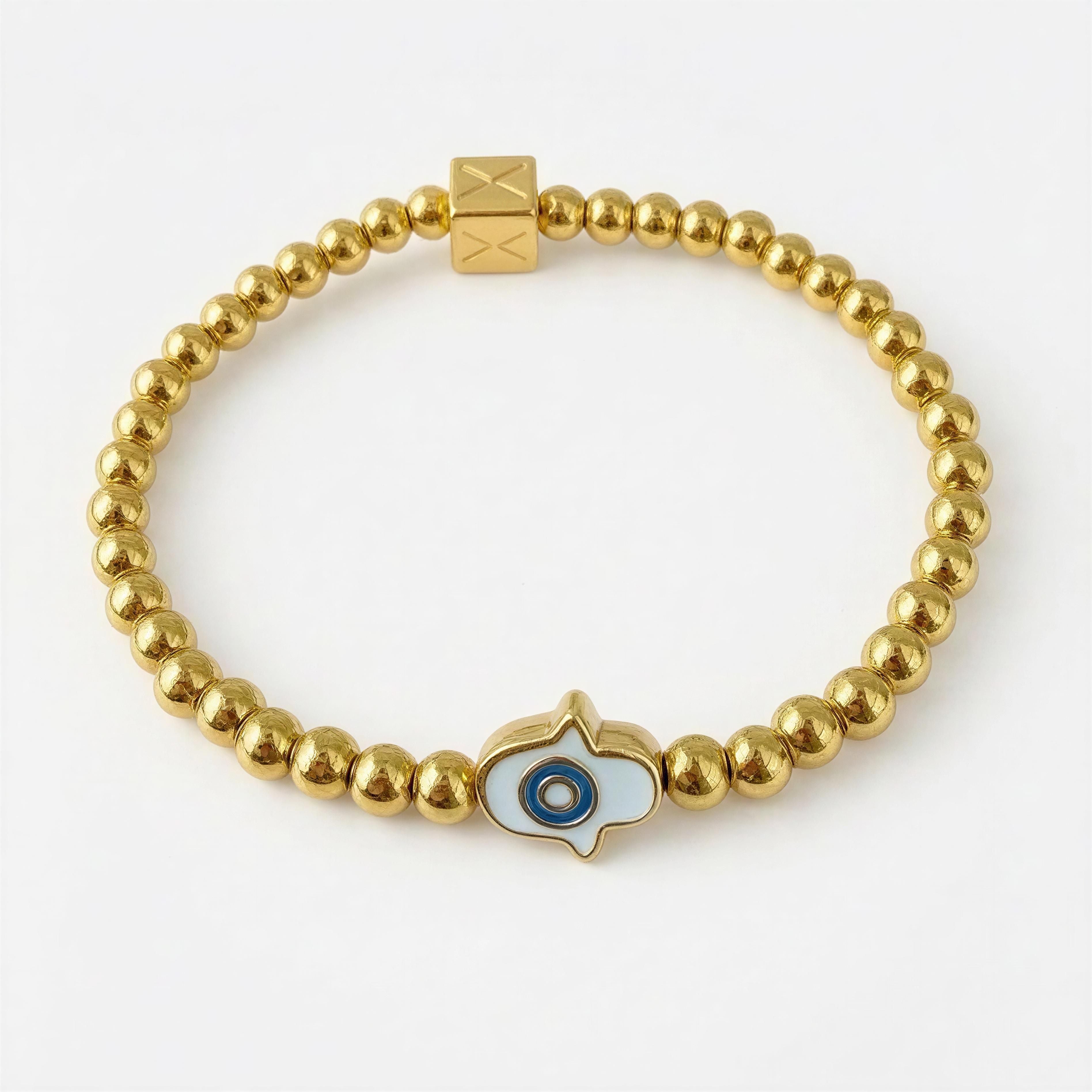 The Little Icon By Xenna Xava – Golden Eye bracelet featuring polished gold beads and a central enamel charm resembling an eye, embodying luxury handcrafted jewelry.