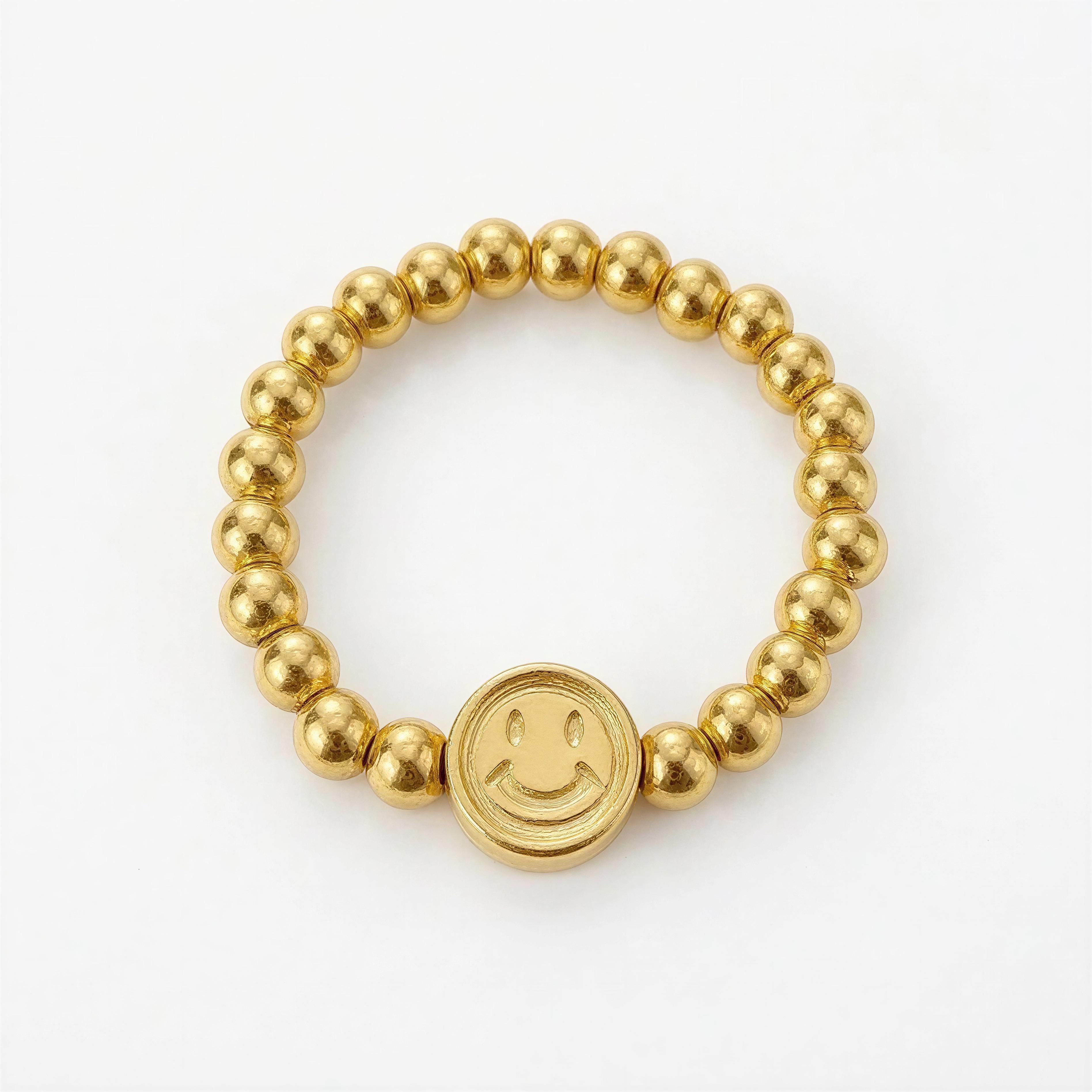 RING – Soleil Smile features a delicate gold beaded band with a central smiley face charm, blending playful design with handcrafted luxury jewelry.