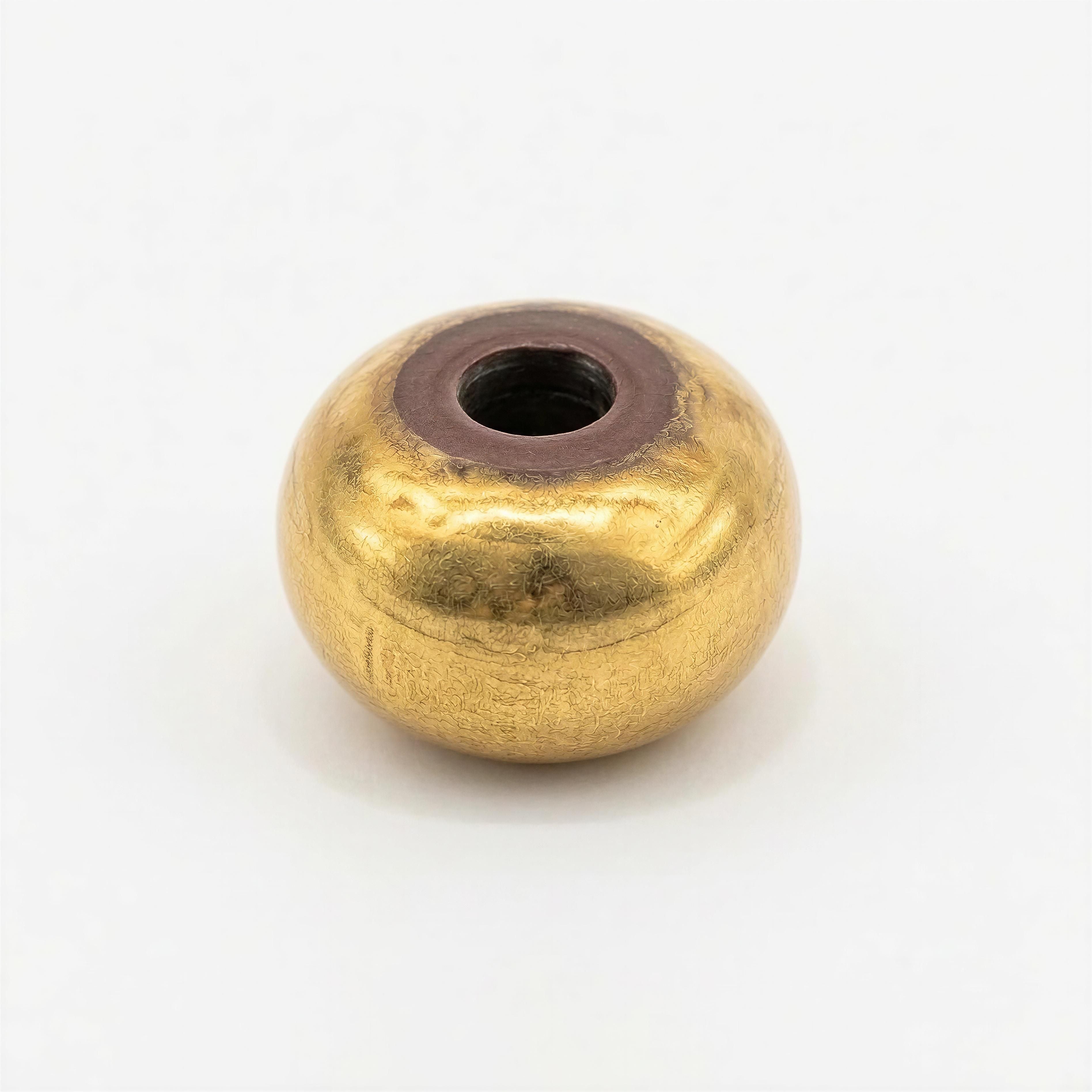 Close-up of a single gold-toned bead with a smooth, rounded oval shape and a textured finish, part of The Essential Collection - 8mm Aurea Ovalis handcrafted jewelry.