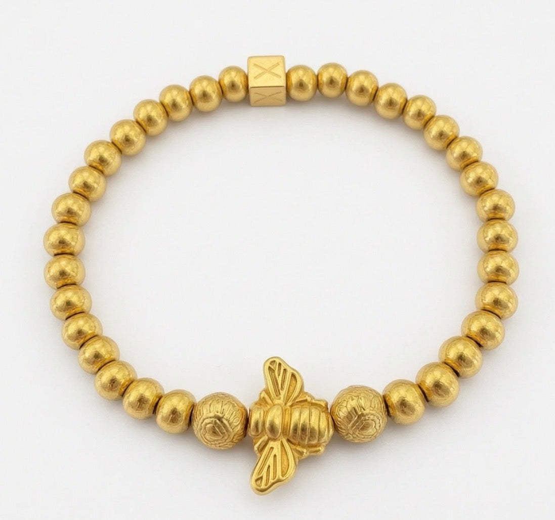Elegant gold beaded bracelet featuring a detailed bee charm and textured beads, part of the Timeless Collection - Regina Apis, showcasing handcrafted luxury jewelry.