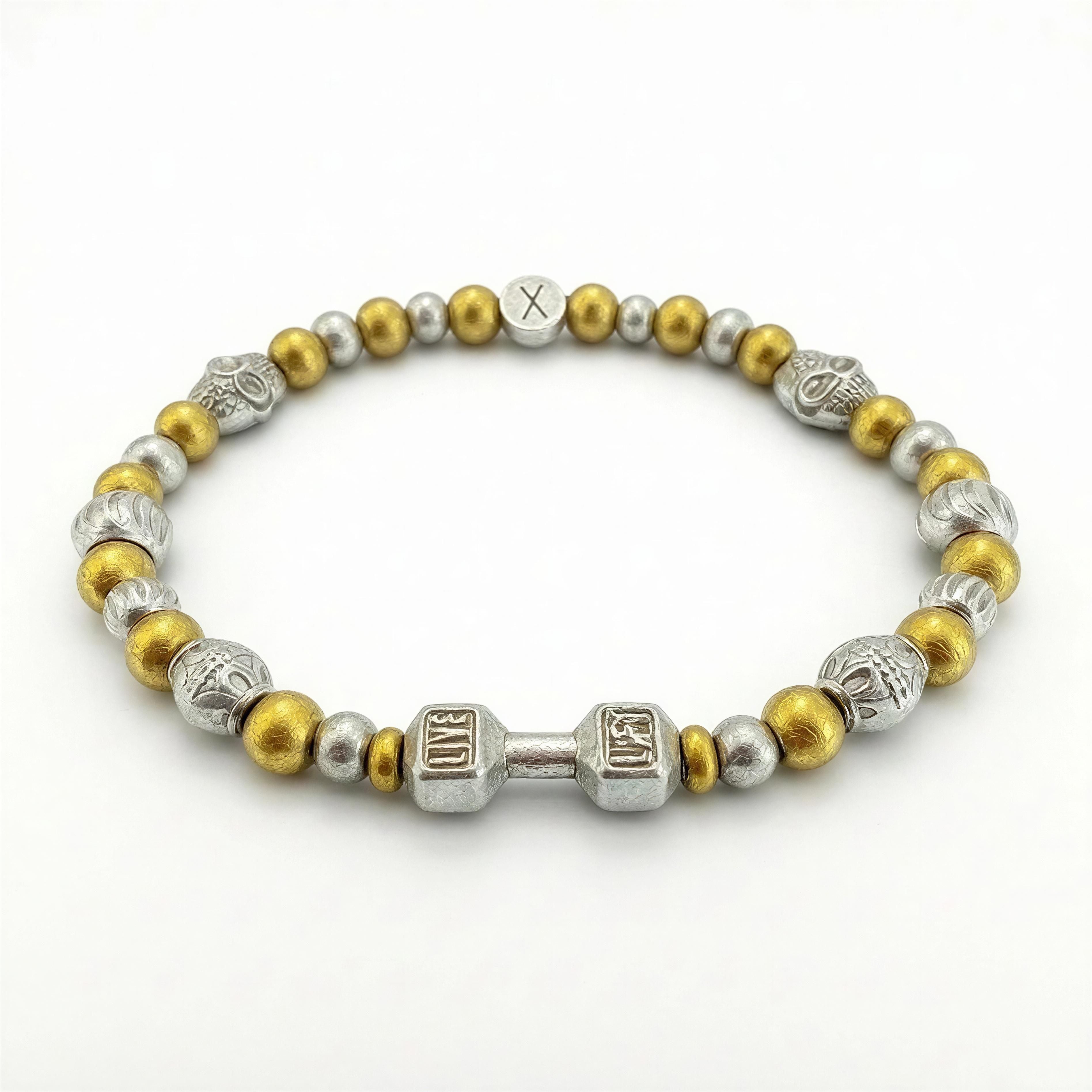 THE X FOR HIM - Live with Strength bracelet featuring gold and silver beads with a detailed dumbbell charm symbolizing power and resilience in handcrafted luxury jewelry style.