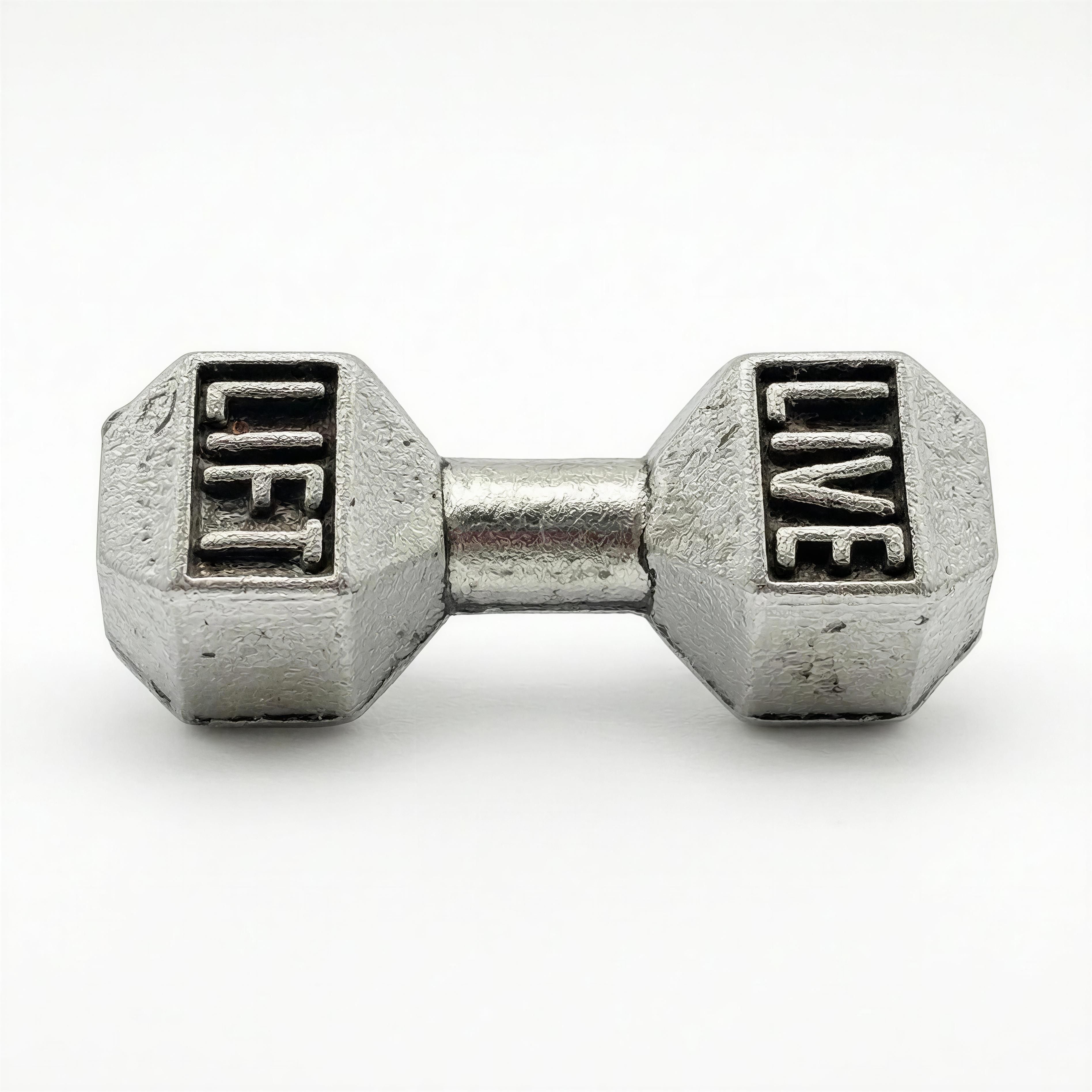 Close-up of a silver charm shaped like a dumbbell with the words "LIFT" and "LIVE" engraved on each end, part of The Iron Legacy Bracelet collection.