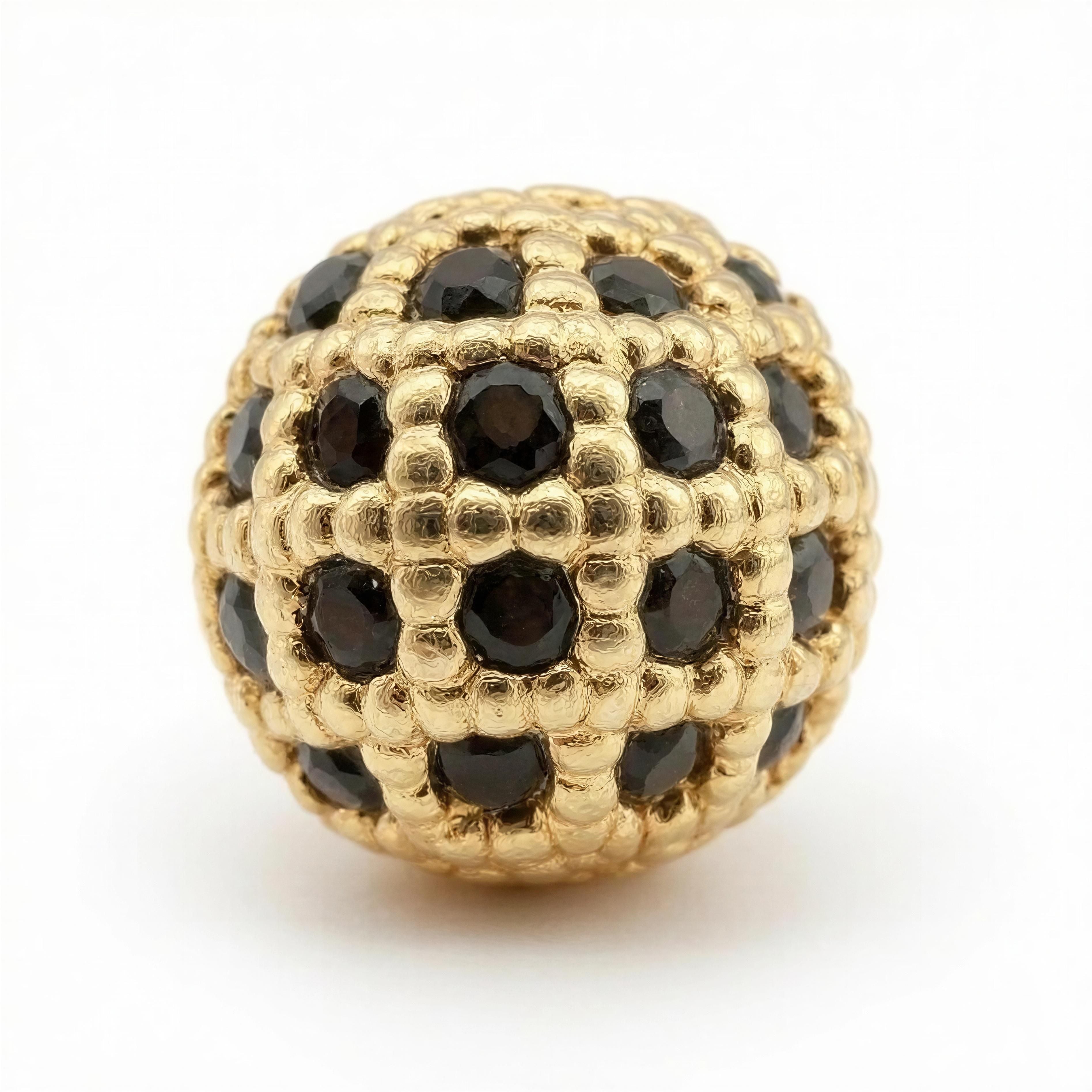 Close-up of a spherical gold bead with a textured lattice design, inset with multiple faceted black stones, from the Limited Edition- Aurea Nox Imperium collection.