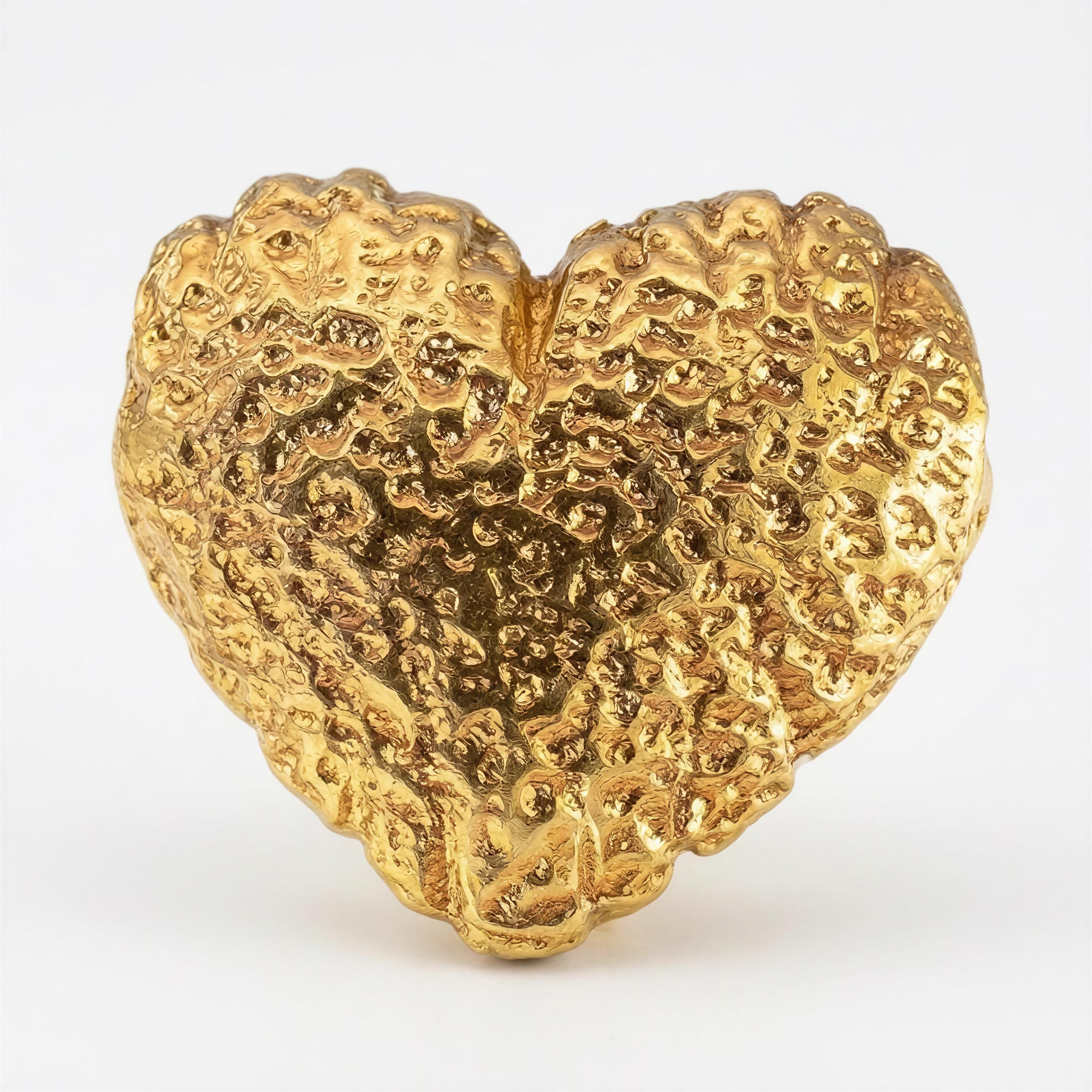 Close-up of a textured gold heart-shaped bead from the Timeless Collection - Amor Aurea, showcasing handcrafted luxury jewelry design.