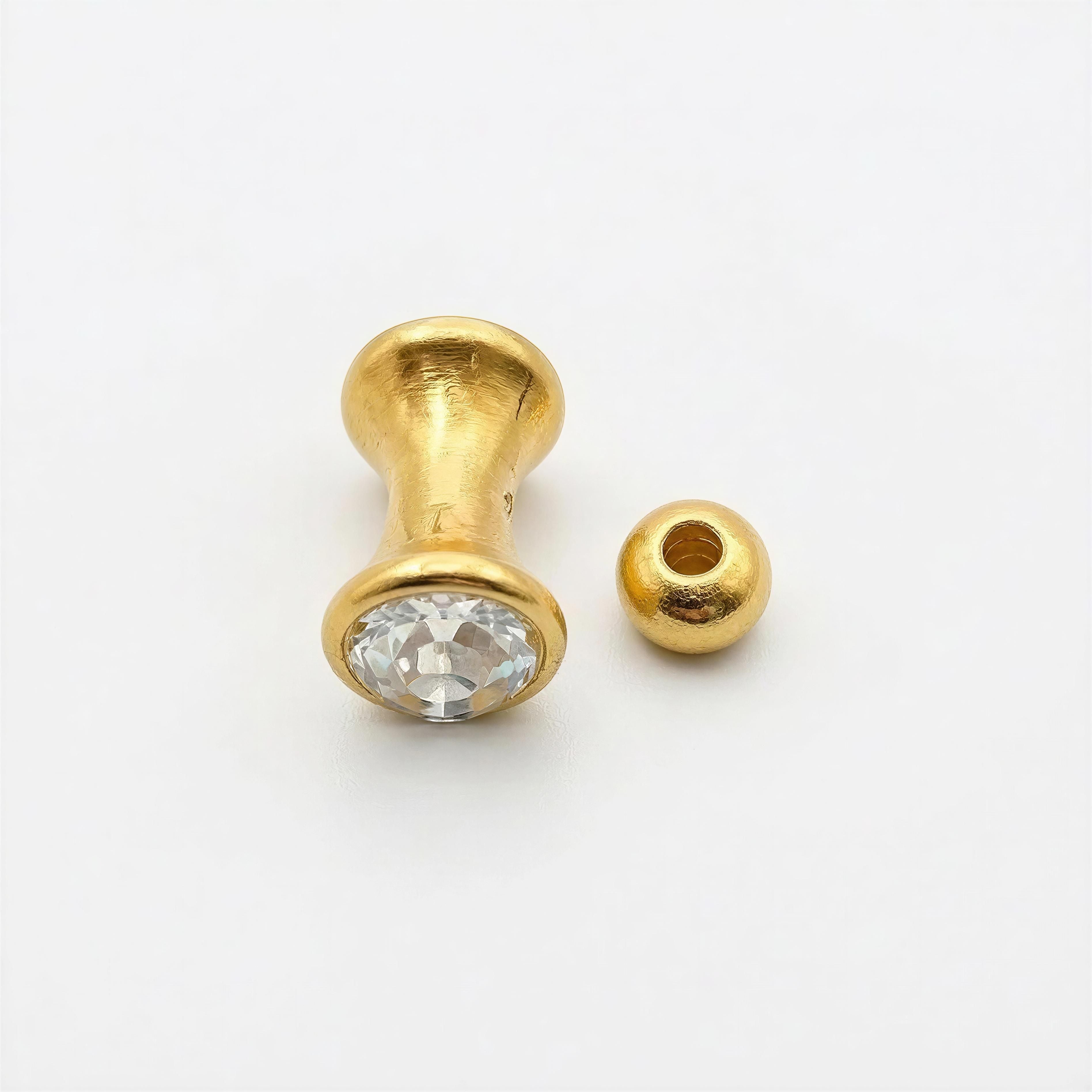 Close-up of a RING Golden Light bead featuring a faceted clear gemstone set in gold-toned metal alongside a smooth gold bead, reflecting luxury handcrafted jewelry style.